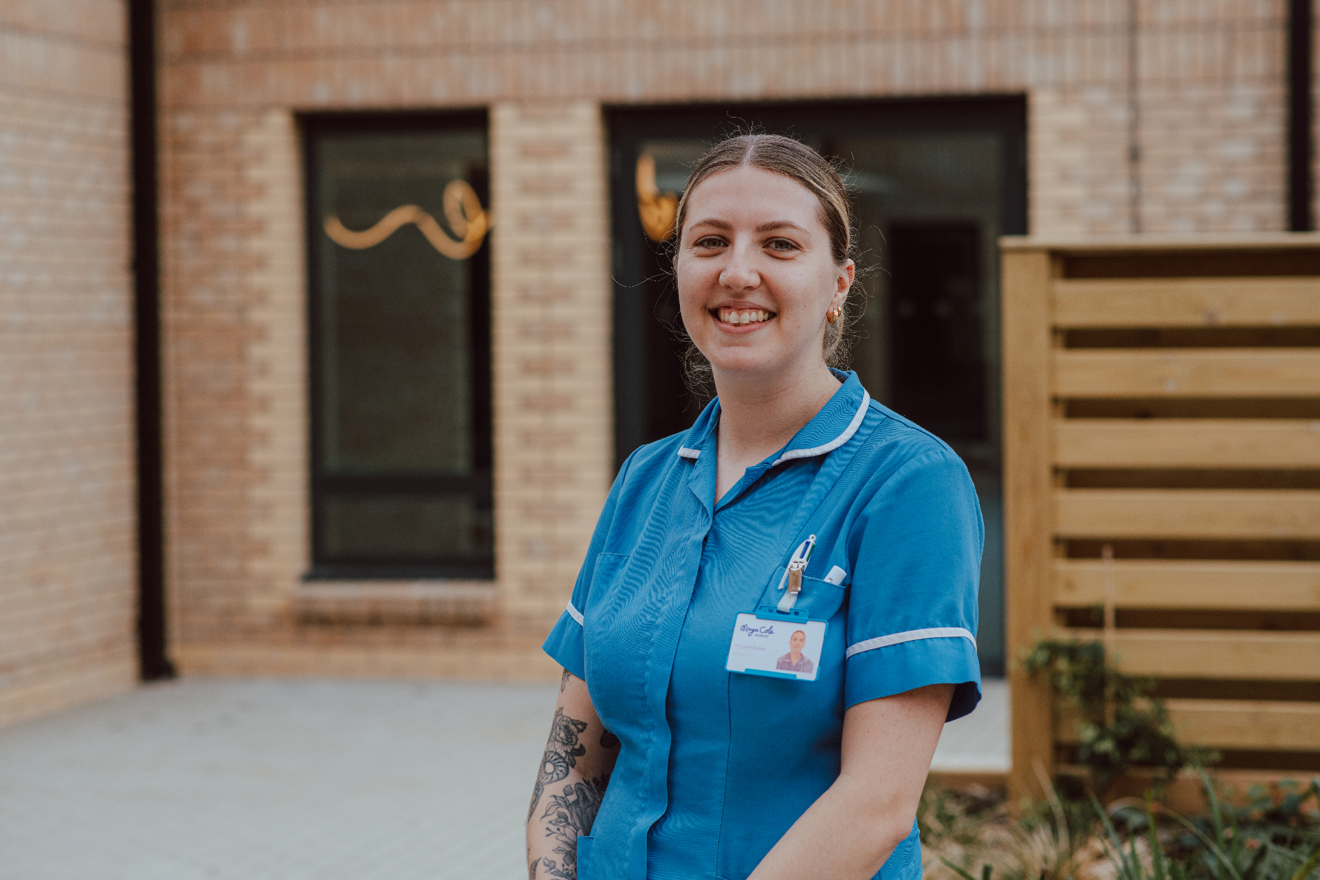 Moya Cole hospice nurse smiling outside the hospice building